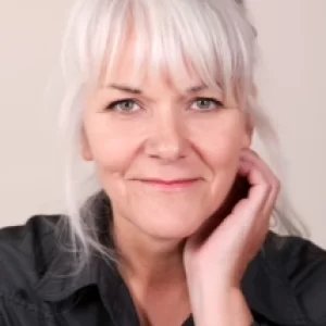 smiling woman with white hair and black shirt posing for a picture