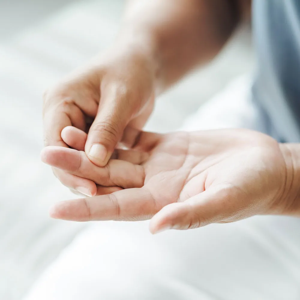 someone holding a small hand in their palm with a white sheet