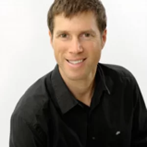 man in black shirt sitting down and smiling