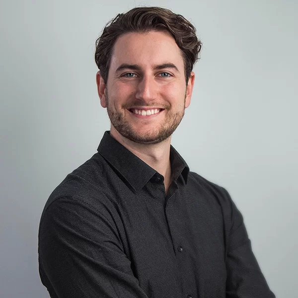 smiling man in black shirt with arms crossed and arms crossed