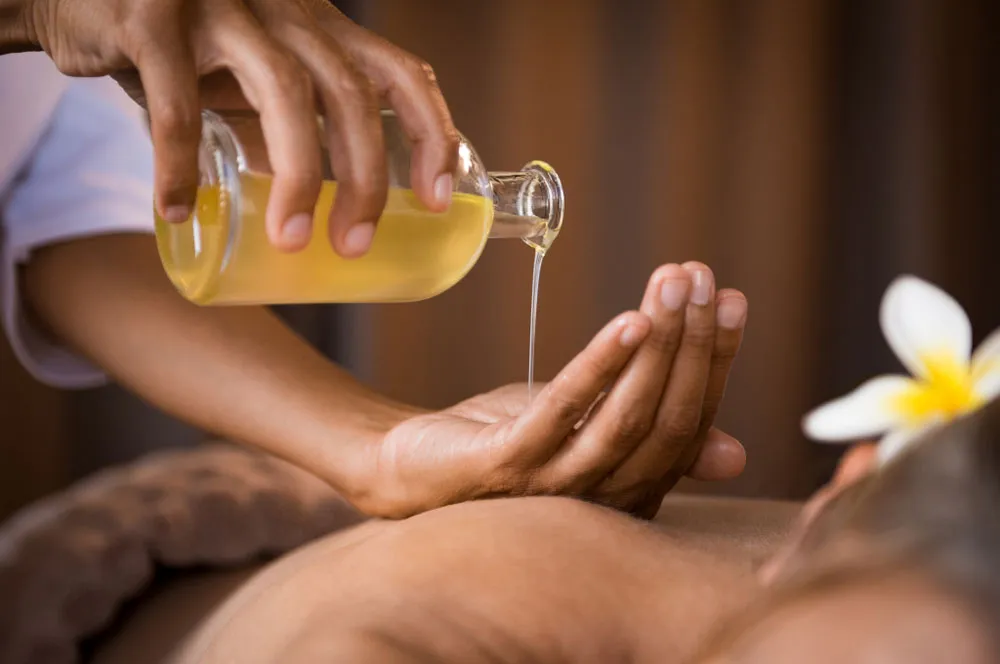 someone is getting a massage at a spa with a bottle of oil